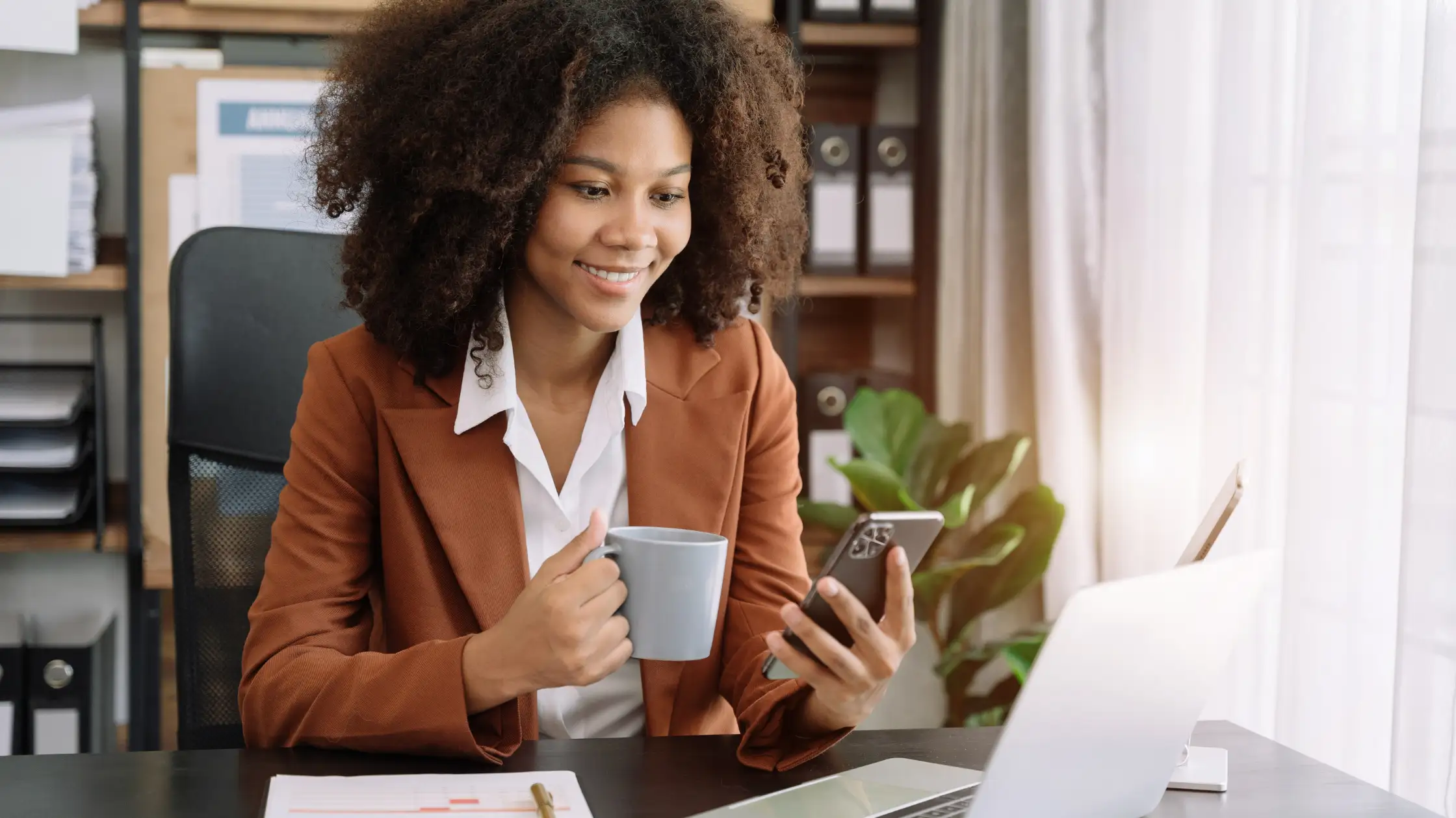 professional woman reading email while taking coffee