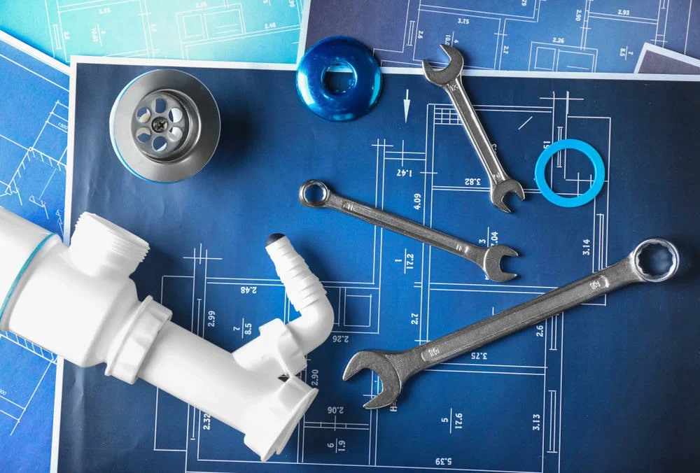 Plumbing tools and blueprints for home repairs in Texas.